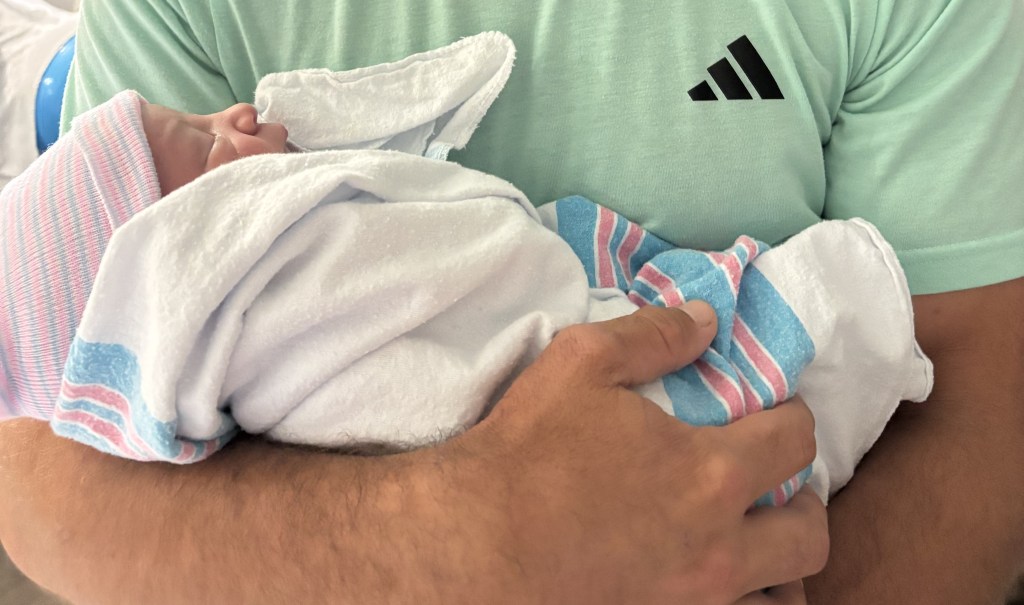 Dr. John McHugh Georgia vasectomy reversal success baby in father's arms.